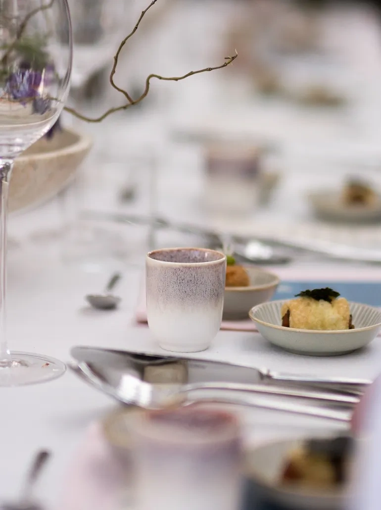 Une table dressée pour le dîner de dégustation avec des couverts Sola et des assiettes Lunasol