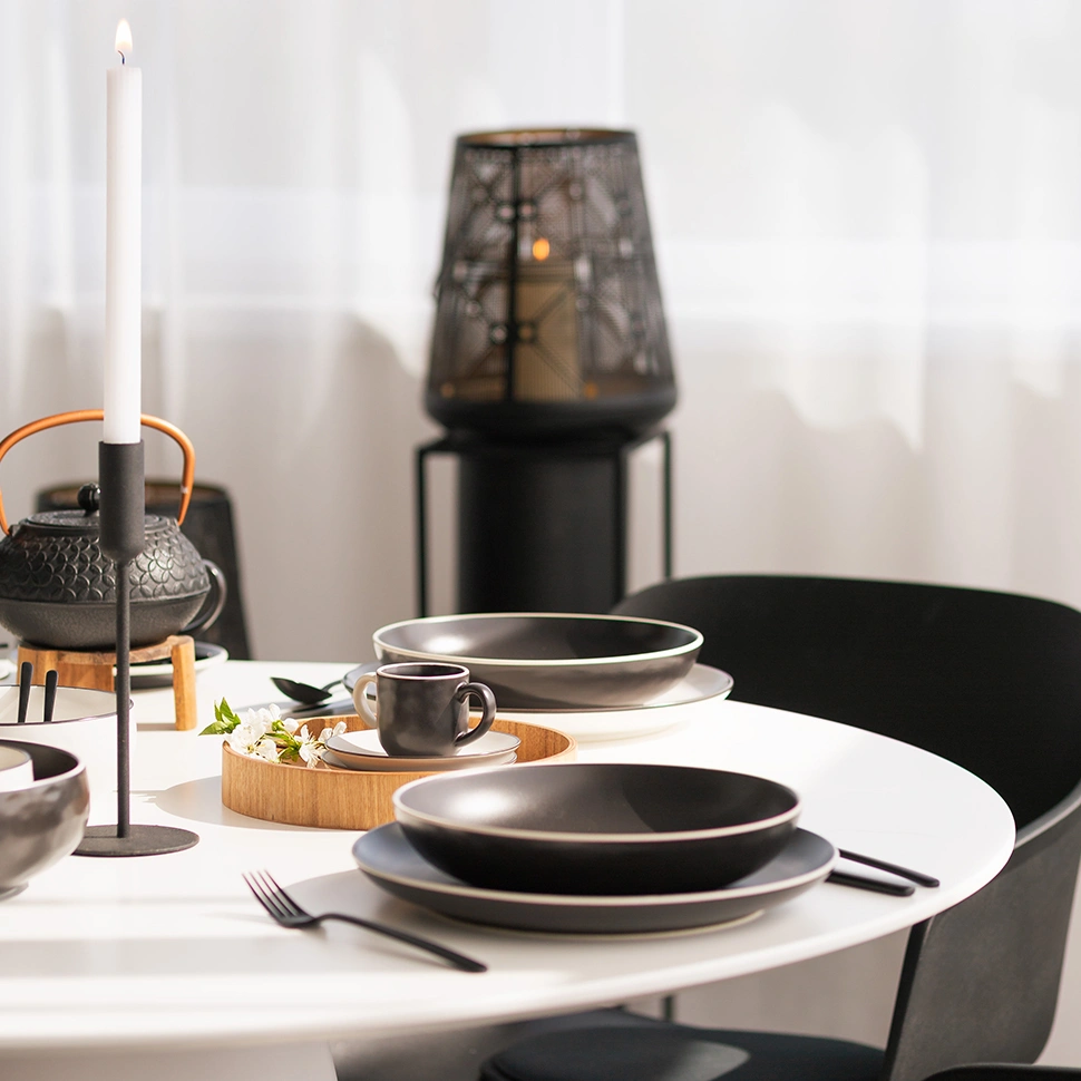 Set table with black porcelain, a teapot and a lantern