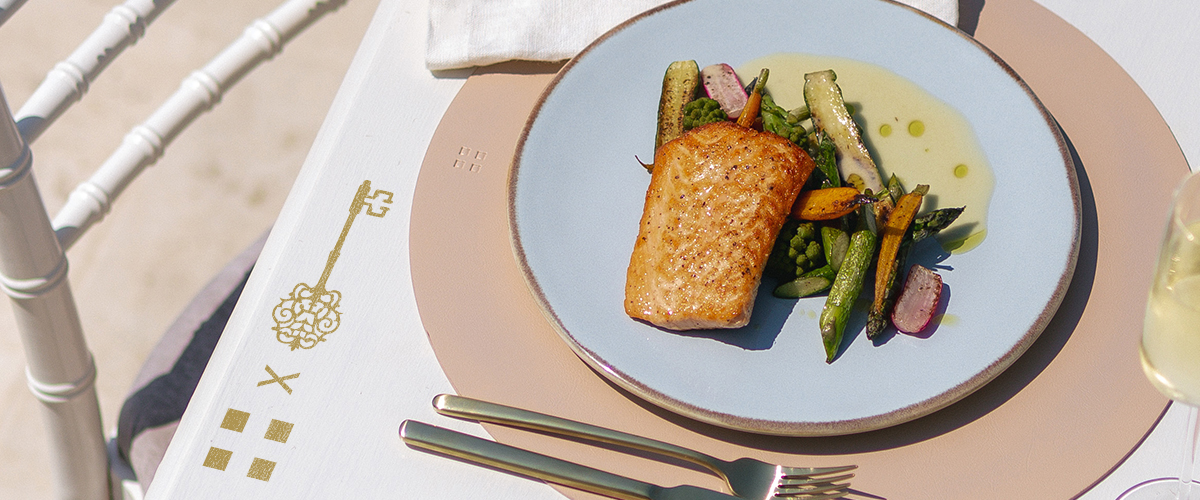 Gegrillter Lachs mit Gemüse, serviert auf einem Teller auf einem gedeckten Tisch 